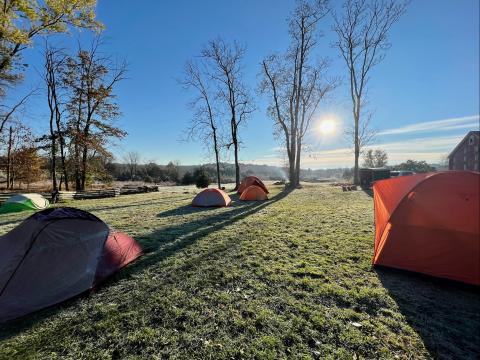 Tents in a field at sunrise