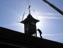 Restoration placement of the center copula on the barn.